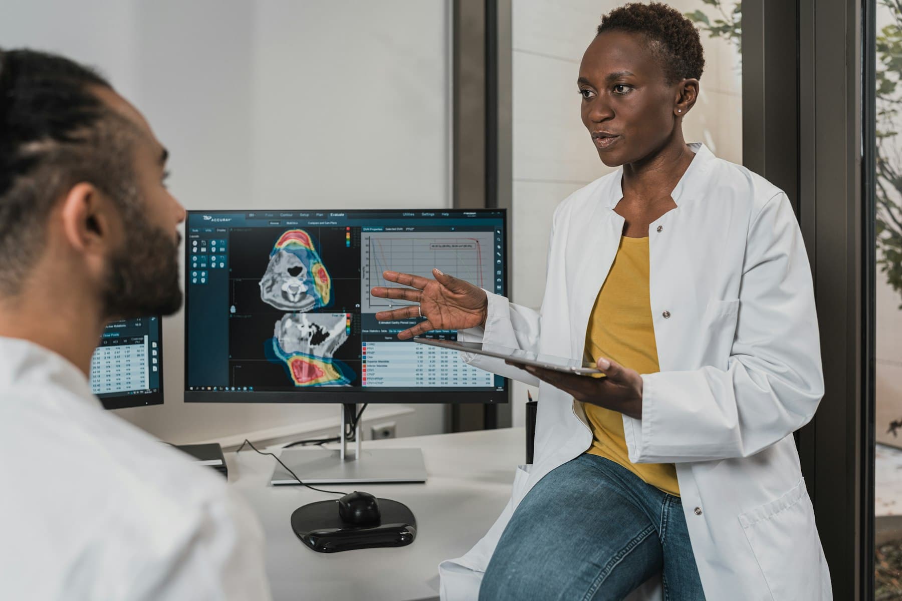 Médica revisando imágenes diagnósticas con un colega