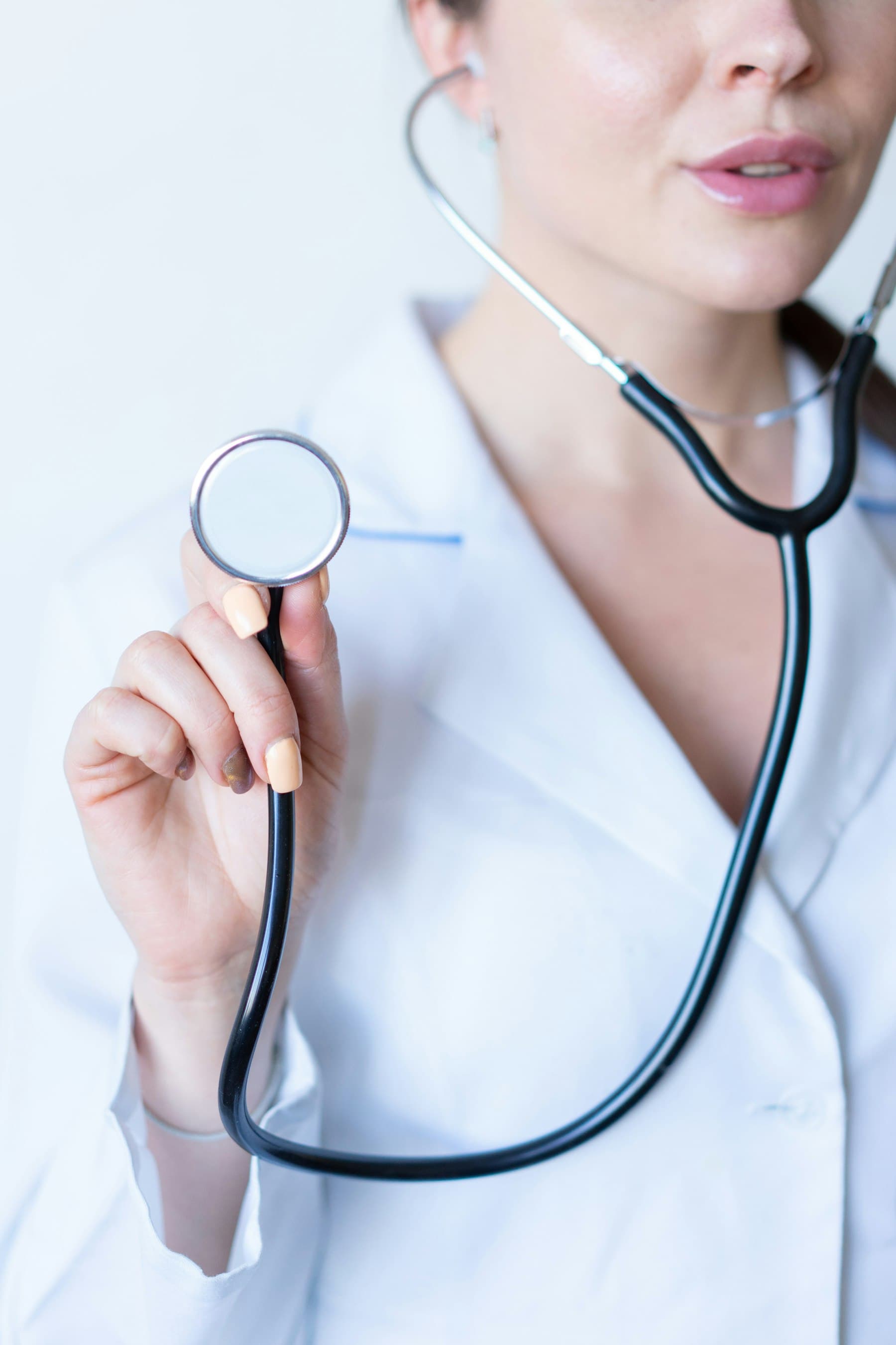 Mano de una médica sosteniendo un estetoscopio